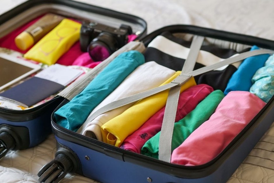 A compact suitcase packed neatly with colorful clothing.